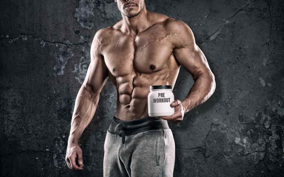 a bodybuilders holds a pre-workout supplement